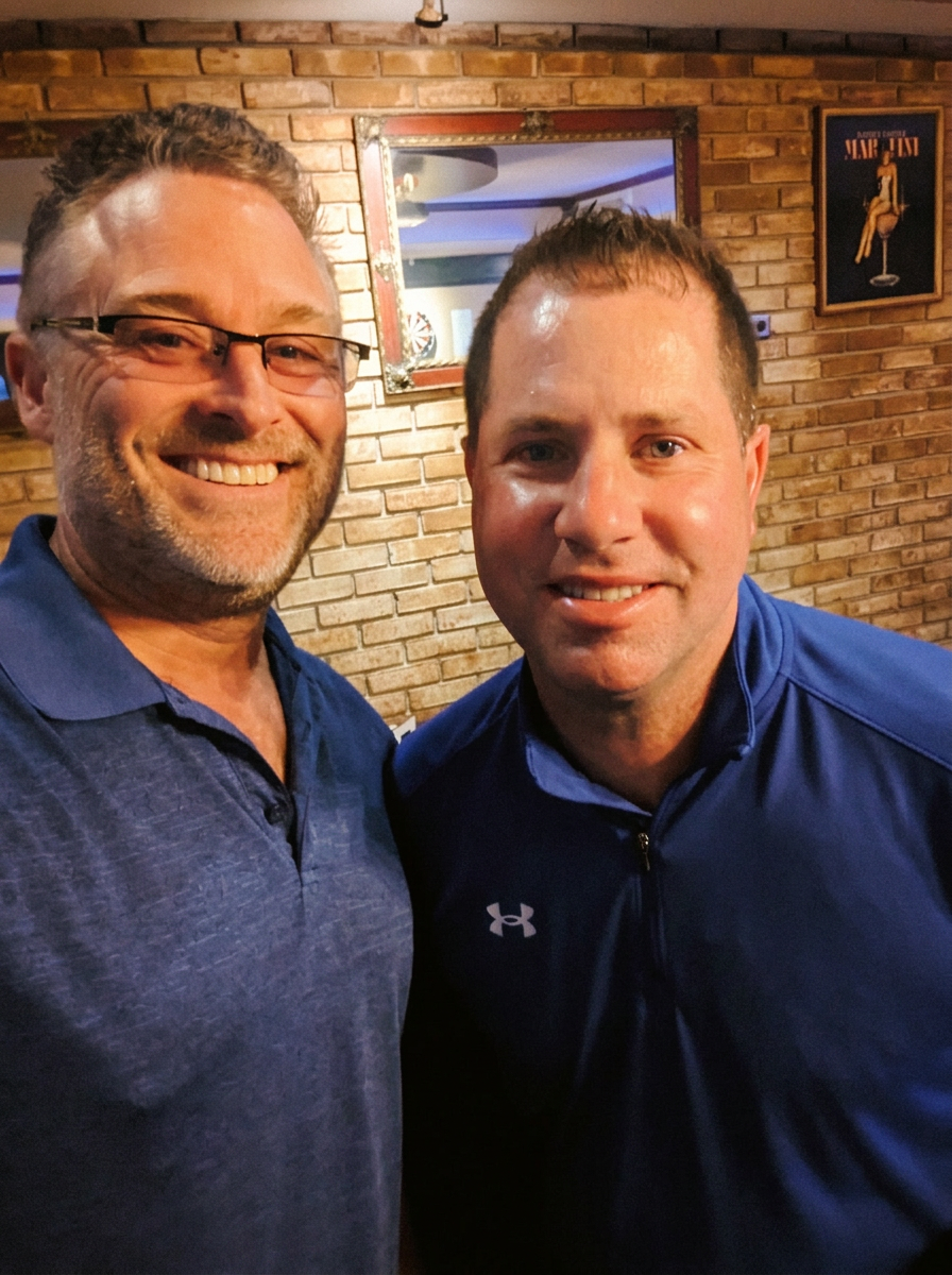 Todd (left, in glasses) and Russ smiling side by side, warm editorial parchment tone